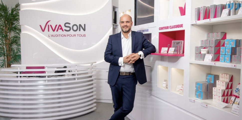 Un audioprothésiste VivaSon souriant à l'accueil de son centre.